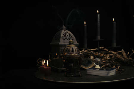 Talking spiritual board with black candles and old key. Wicca, esoteric and occult background with vintage magic objects for mystic rituals. Halloween and gothic concept.の写真素材