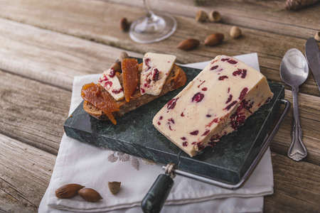 An assortment of various types of cheese with wine, and grapes, shot from above on a dark rustic background with a place for text, square photo.の写真素材