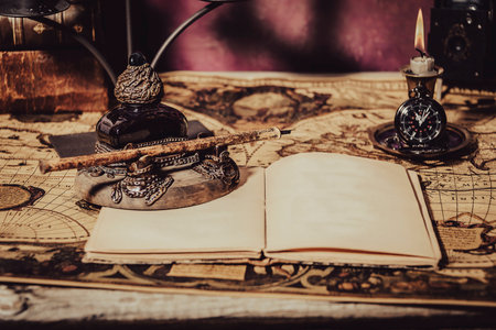 Vintage wallpaper with copy space. Antique desk with inkwell and pen writing a book on a blueprint.の写真素材