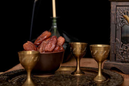 Tea and dried dates on a old wooden table.の写真素材