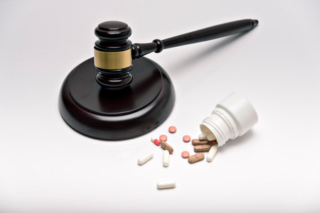 Medicine and law. Pills capsules and judge gavel isolated on white background.の写真素材