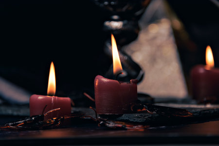Witchcraft composition with burning candles, jewelry and pentagram symbol. Halloween and occult concept, black magic ritual.の写真素材