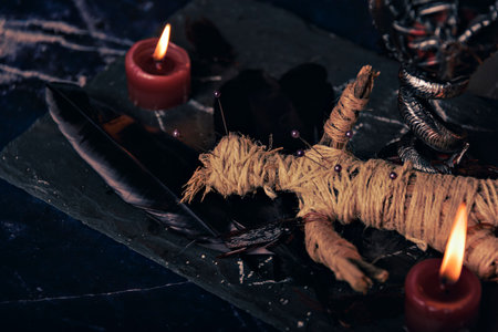 Voodoo Magic concept. Voodoo doll studded with needles with pierced rag heart on pentagram and around burning candles. Spooky or eerie magical esoteric ritual.の写真素材