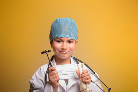 Cute child in doctor coat with stethoscope on color background. Space for text.の写真素材