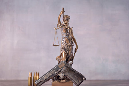 Gun in the foreground with the background is a representation of justice. Concept of use of arms and justiceの写真素材