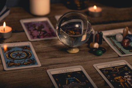 Tarot cards including The Fool and The Lovers alongside crystals and candles on a textured wooden...