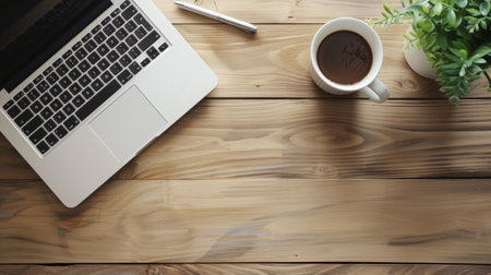 A laptop sits beside a cup of coffee on the wooden table, showcasing a blend of technology and coziness in a simple yet inviting settingの写真素材