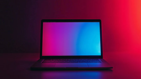 A laptop with a gradient screen illuminated in soft pink and blue lighting, creating a minimalist and modern aesthetic in a dark room.の素材
