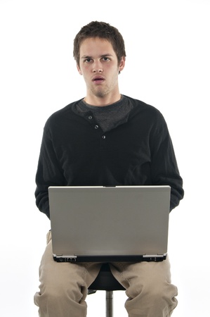 teenage boy on white background with laptop looking confusedの写真素材