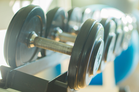 Black dumbbell set. Close up many metal dumbbells on rack in sport fitness centerの写真素材