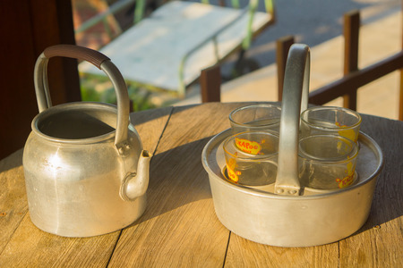 Kettle and glass on wooden tableの写真素材