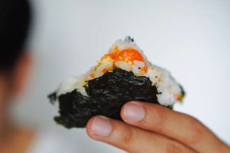 close up sushi triangle in hand.の写真素材