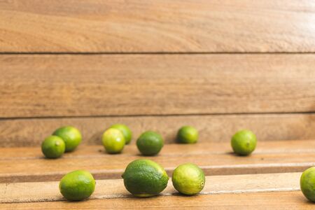 Fresh green lemons on wooden bottomの写真素材