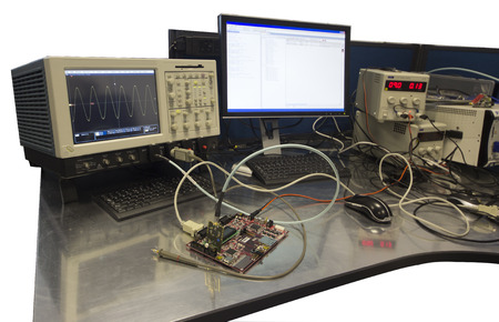 Isolated electronic engineer work bench with connected circuitboard for testingの写真素材