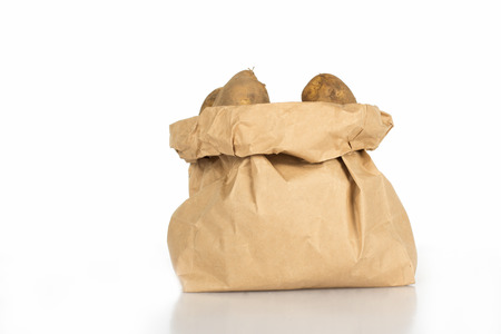Paper bag of unwashed potatoes  isolated on whiteの写真素材