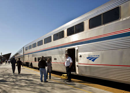 AmTrak Conductor and passengers on a sunny platform.のeditorial素材