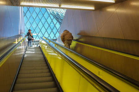 Two people riding an art museum escalator.のeditorial素材