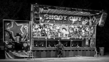 B&W Carnival Game Barker at nightのeditorial素材