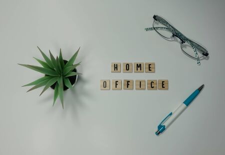 The word home office written in wooden letter tiles on a white background.  Concept work from home, technology, workspace, and lifestyle.の写真素材