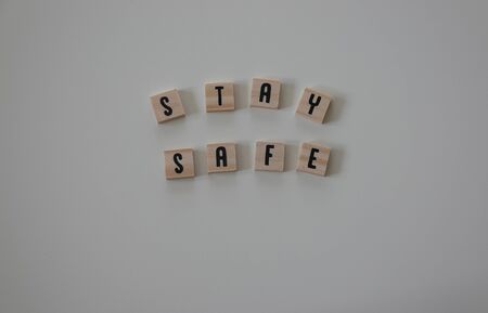 Stay Safe written in wooden letter tiles on a white background.  Concept safety, emergency, hurricane, danger, coronavirus, pandemic, protection, snowstorm, tornado and flu.の写真素材