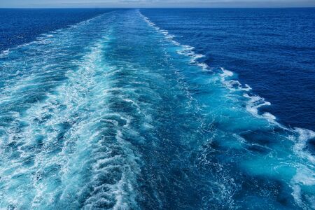 A Cruise ship wake on a beautiful sunny day with white clouds and blue seas on the Atlantic Ocean.の写真素材