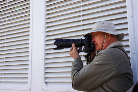 Alaska/USA-9/11/19:A man taking photos while on vacation on a cruise ship.のeditorial素材