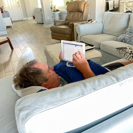 Orlando,FL USA - January 25, 2021:  A senior man reading the news on his iPad while laying on the...