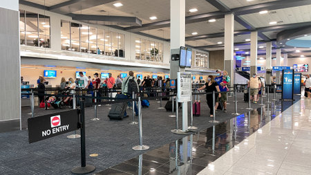 Sanford, FL USA - May 13, 2021:  People waiting to get their tickets at an Allegiant  airline checkin counter at a busy  airport.のeditorial素材