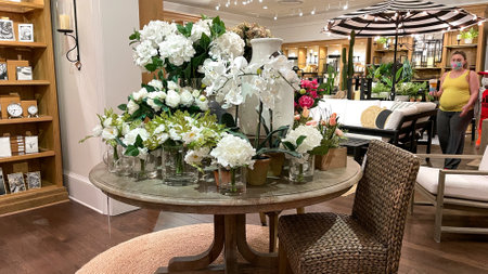 Orlando, FL USA - April 25, 2021:  A dining table with silk flowers and vases for sale at a Pottery Barn Retail Store in Orlando, Florida.のeditorial素材