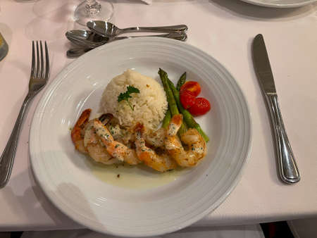 A dinner of shrimp, rice and asparagus at a cruise ship restaurant.の写真素材