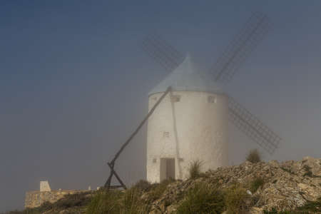 Windmill covered by fog in Consuegra, Toledoの写真素材