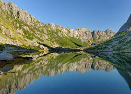 Mountains Reflecting In The Water On Lofoten Island Austvagoy On A Sunny Summer Day With A Clear Blue Skyの写真素材