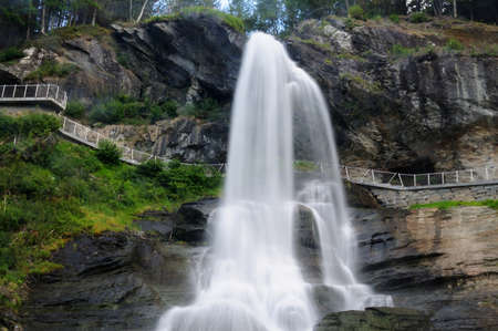 Long Time Exposure Of Steindalsfossen Falls In The Fosselva River In Norway On A Sunny Summer Day With A Clear Blue Sky And A Few Cloudsの写真素材