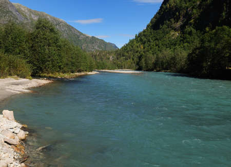 The Beautiful Turquoise Water Of The Lustrafjord On A Sunny Summer Day With A Clear Blue Sky And A Few Cloudsの写真素材
