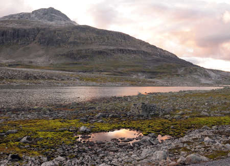 The Barren Landscape Of The Icefield Of Aurlandsfjellet At Dusk On A Sunny Summer Day With A Clear Blue Sky And A Few Cloudsの写真素材