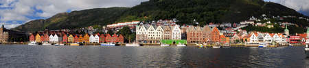 Panorama View To The Historic Painted Wooden Houses Of Bryggen In Bergen On A Sunny Summer Day With A Clear Blue Sky And A Few Cloudsの写真素材