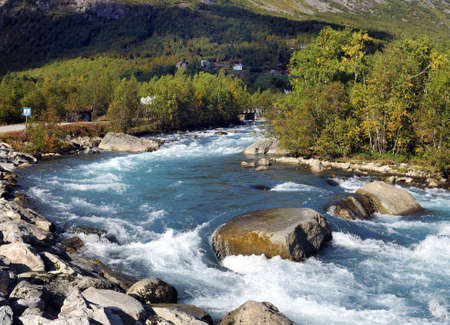 Beautiful Wild River Jostedola With Water Passing Large Rocks And Boulders In Jostedalsbreen National Park On A Sunny Summer Dayの写真素材