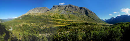 Panorama View Of The Mountains In The Barren Landscape Of The Icefields Of Jotunheimen National Park On A Sunny Summer Day With A Clear Blue Sky And A Few Cloudsの写真素材