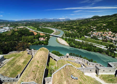 View From The Fortress Of Sisteron To The Green Shimmering River Durance In France On A Beautiful Spring Day With A Clear Blue Skyの写真素材