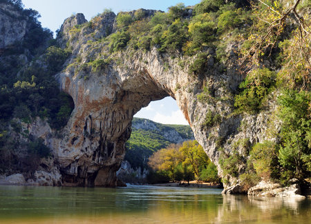 Rock Arch Pont D'Arc In The Canyon Of The Gorges De L'Ardeche With Reflections On The River Ardeche In France On A Beautiful Autumn Day With A Clear Blue Skyの写真素材