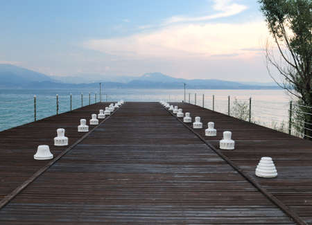 Wooden Pier In Sirmione At Lake Garda On A Beautiful Spring Day With A Blue Sky And A Few Cloudsの写真素材
