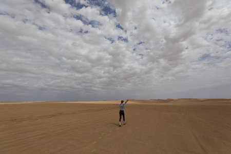 A young woman standing in the middle of the Sahara desert, Moroccoの写真素材
