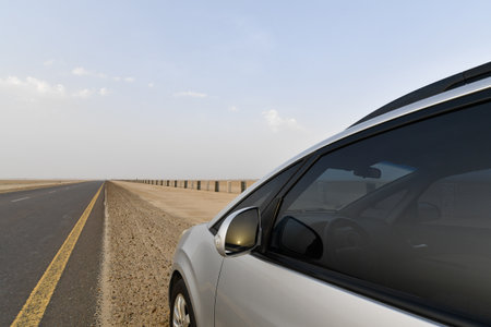 Car on the road in the middle of the desert with blue skyの写真素材