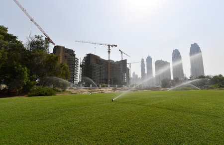 watering the lawn in front of the modern skyscrapers.の写真素材
