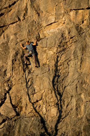 a person climber climbing a steep rock wallの写真素材