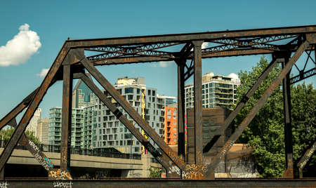 Rusty bridge on a sunny day with buildings in the backgroundのeditorial素材