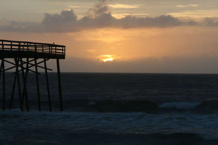 sunrise over ocean with pierの写真素材