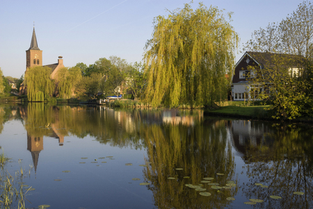 View over th river Graafstroom to the church of the small village Bleskensgraaf in the Dutch region Alblasserwaardの写真素材