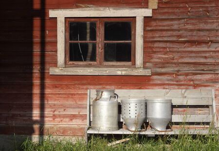 Farming equipment in front of a falured painted barn in the Norwegian region Gudbrandsdalenの写真素材