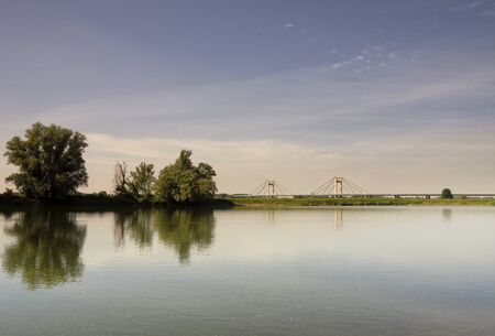 Trees reflecting in a large pond in the floodplain of the river Waal near the village Echteldの写真素材